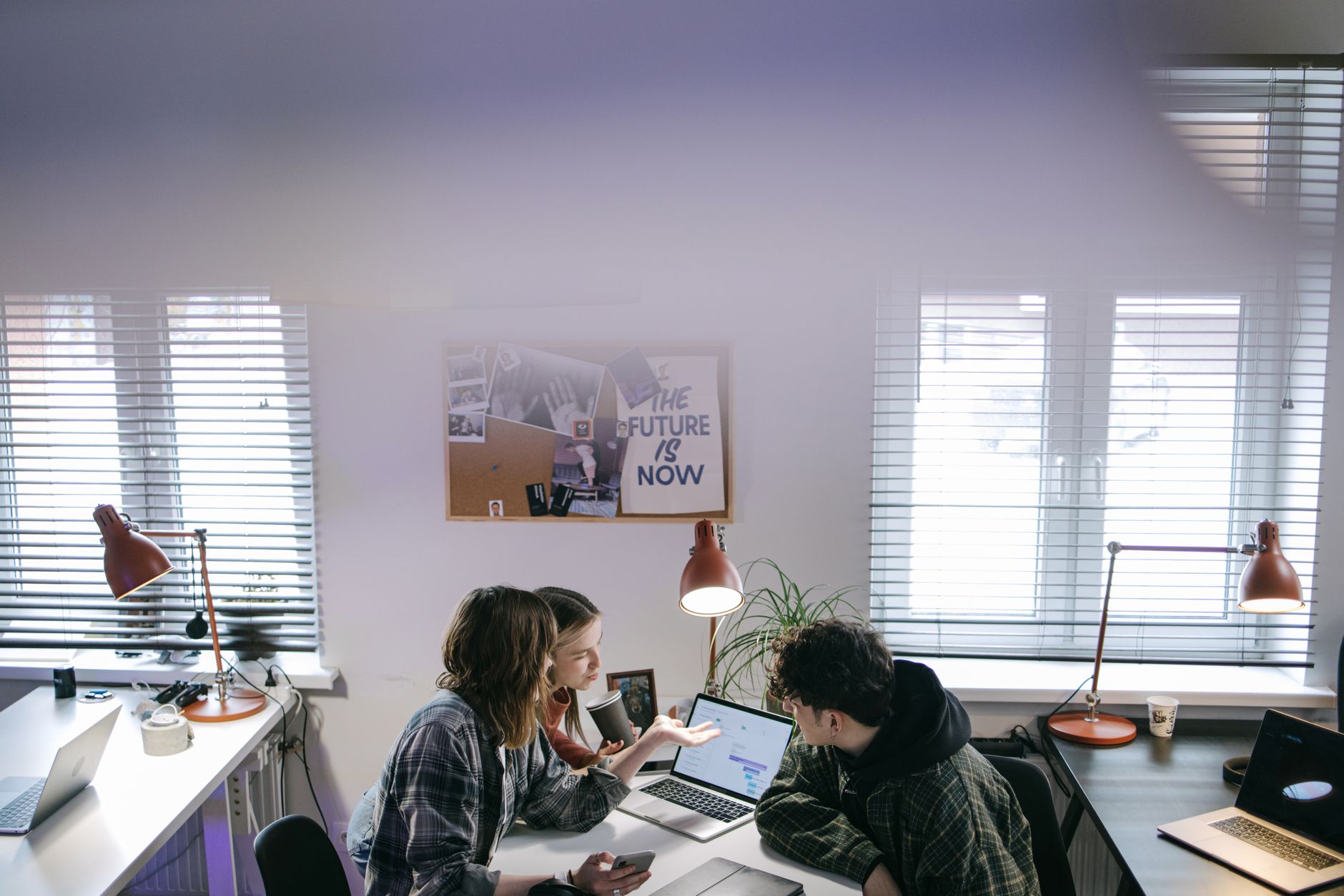 A group of people discussing ideas around laptops in a bright, modern office space — illustrating: MSP Evaluation Guide for Central Florida Businesses: What You Actually Need vs. What Vendors Will Sell You